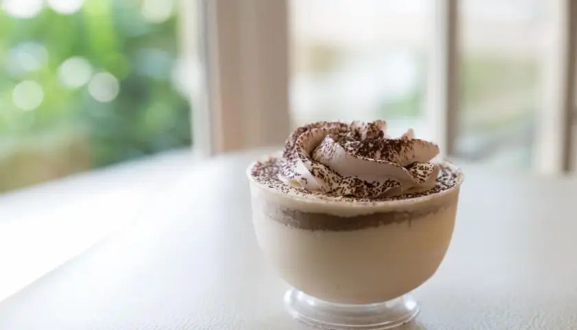 Délicieuse mousse au café sans cuisson, garnie de cacao, dans un verre transparent. Parfait pour une pause gourmande.