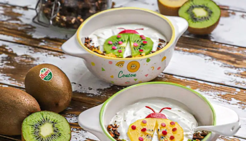 Recette kiwi trop mûr : yaourt et granola décorés d'une coccinelle en kiwi et fruits rouges. Parfait pour un petit-déjeuner ludique.