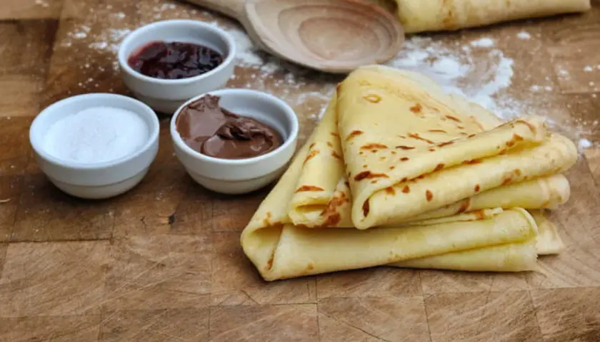 Crêpes sans lactose dorées, accompagnées de confiture, pâte à tartiner et sucre. Un délice pour tous !