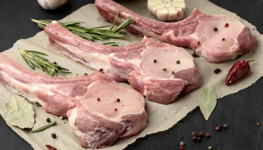 Belle découpe de cochon crue, assaisonnée de poivre et d'herbes, prête pour un festin.