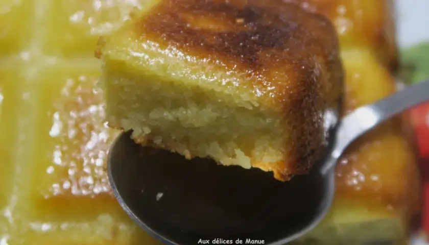 Une cuillère soulève un morceau d'un délicieux gâteau aux amandes sans beurre, doré et moelleux.