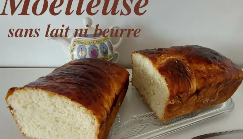Deux belles brioches moelleuses sans lait ni beurre, dorées et appétissantes, prêtes à être dégustées.
