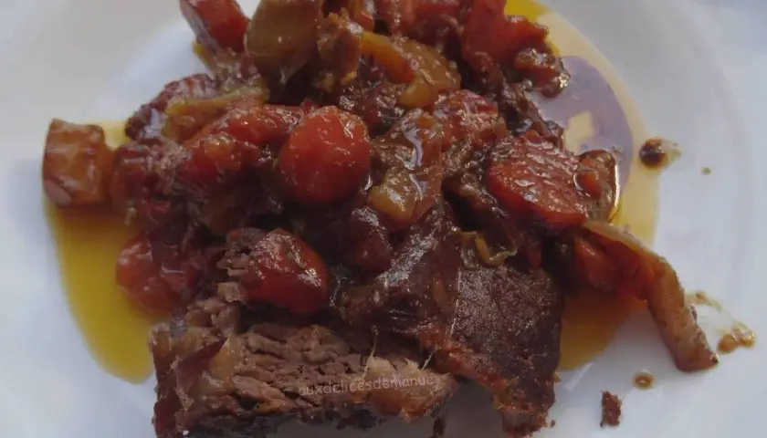 Un morceau de côte de bœuf mijoté, nappé d'une sauce aux tomates et oignons caramélisés. Parfait pour une marinade pour côte de bœuf maison.