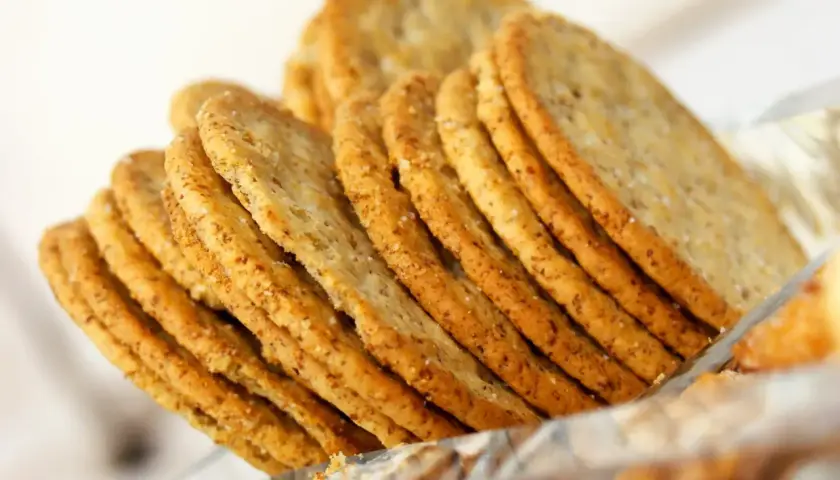 Une pile de crackers croustillants, parfaits pour une recette de crackers fromage. Ils sont dorés et parsemés de sel.