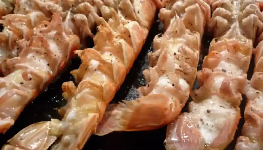 Langoustines grillées, assaisonnées de poivre, prêtes pour un barbecue savoureux.