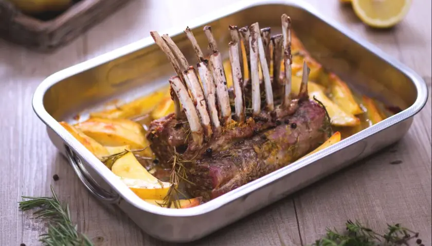 Un délicieux côte d'agneau rôti au four, accompagné de pommes de terre dorées et de romarin frais. Un plat savoureux prêt à être dégusté.