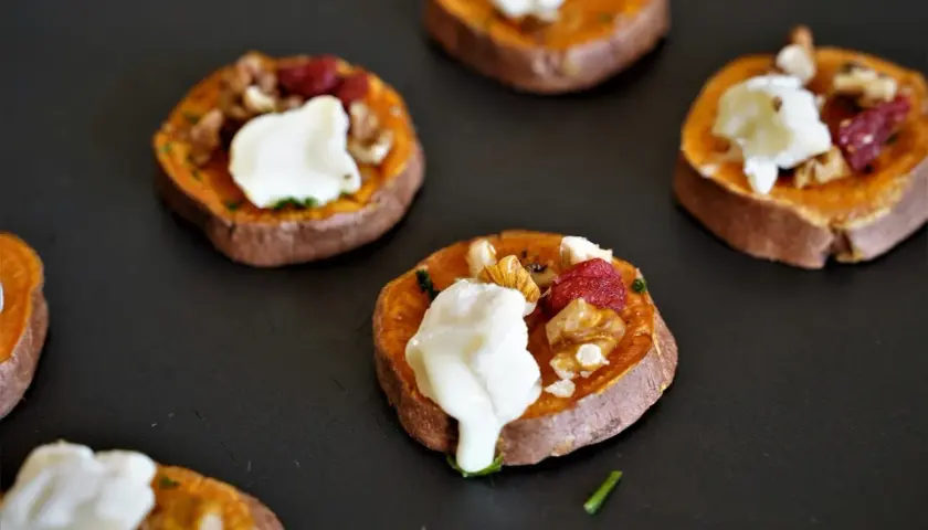 Rondes de patate douce garnies de fromage frais, noix et canneberges. Un délice pour l'apéro patate douce !