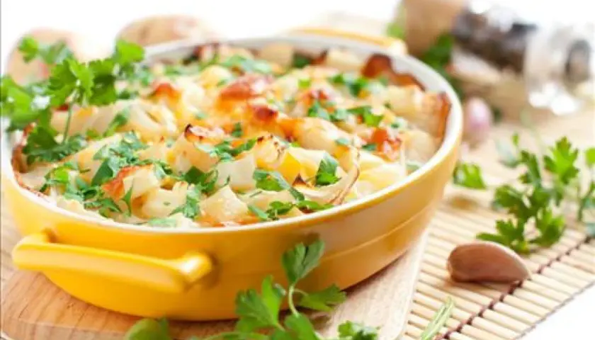 Gratin de chou-fleur et pommes de terre, une des meilleures recettes pour ceux qui n'aiment pas les légumes. Garniture de persil frais.