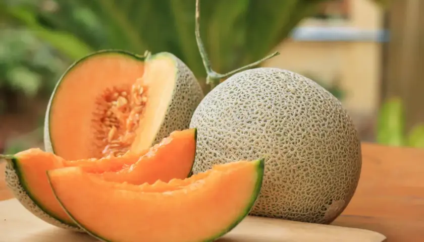 Un melon coupé en quartiers et un entier sur une planche à découper. Idéal pour savoir que faire avec un melon pas bon : le transformer en sorbet !