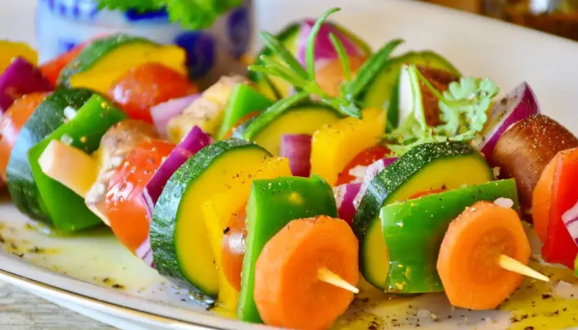 Brochettes de légumes colorées, une excellente idée accompagnement barbecue. Courgettes, poivrons, carottes, tomates et oignons rouges assaisonnés.