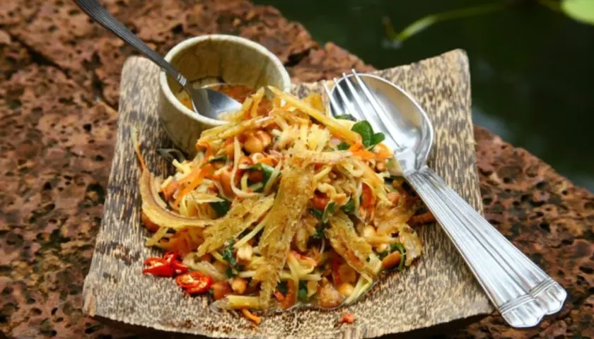 Salade croquante de poisson séché, un plat cambodgien savoureux avec des carottes râpées, des cacahuètes et des piments.