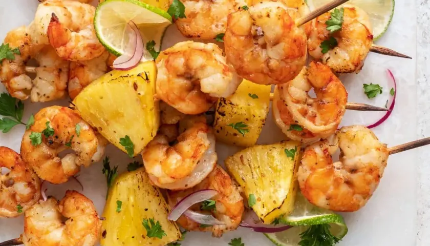 Brochettes de crevette barbecue marinée avec ananas grillé, citron vert et oignon rouge. Un délice estival !