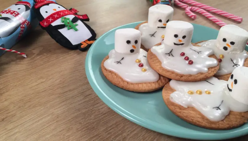 Adorable dessert de Noël pour enfant : biscuits décorés de bonhommes de neige en guimauve fondante.
