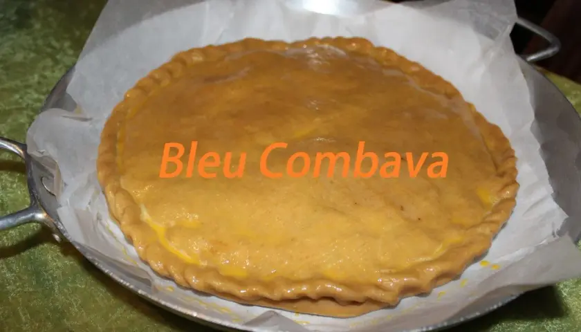 Une empanada gallega dorée, prête à être dégustée. Le texte "Bleu Combava" est superposé.