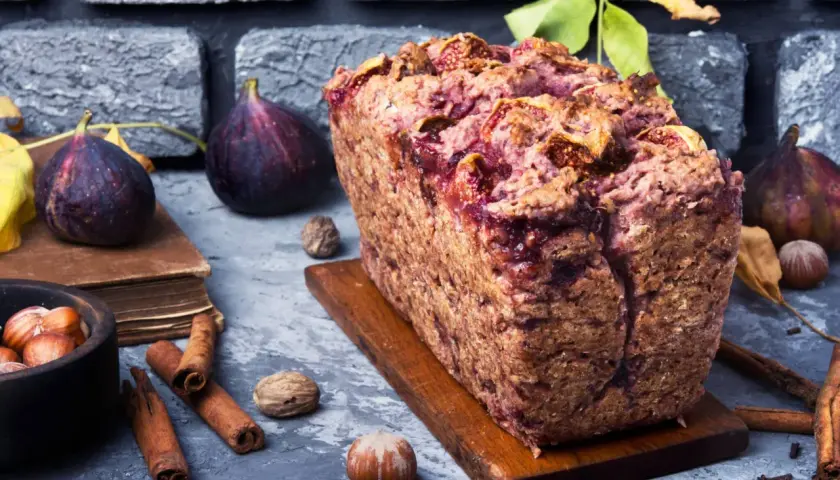 Gâteau rustique aux figues et noix, garni de fruits frais, de cannelle et de noisettes.