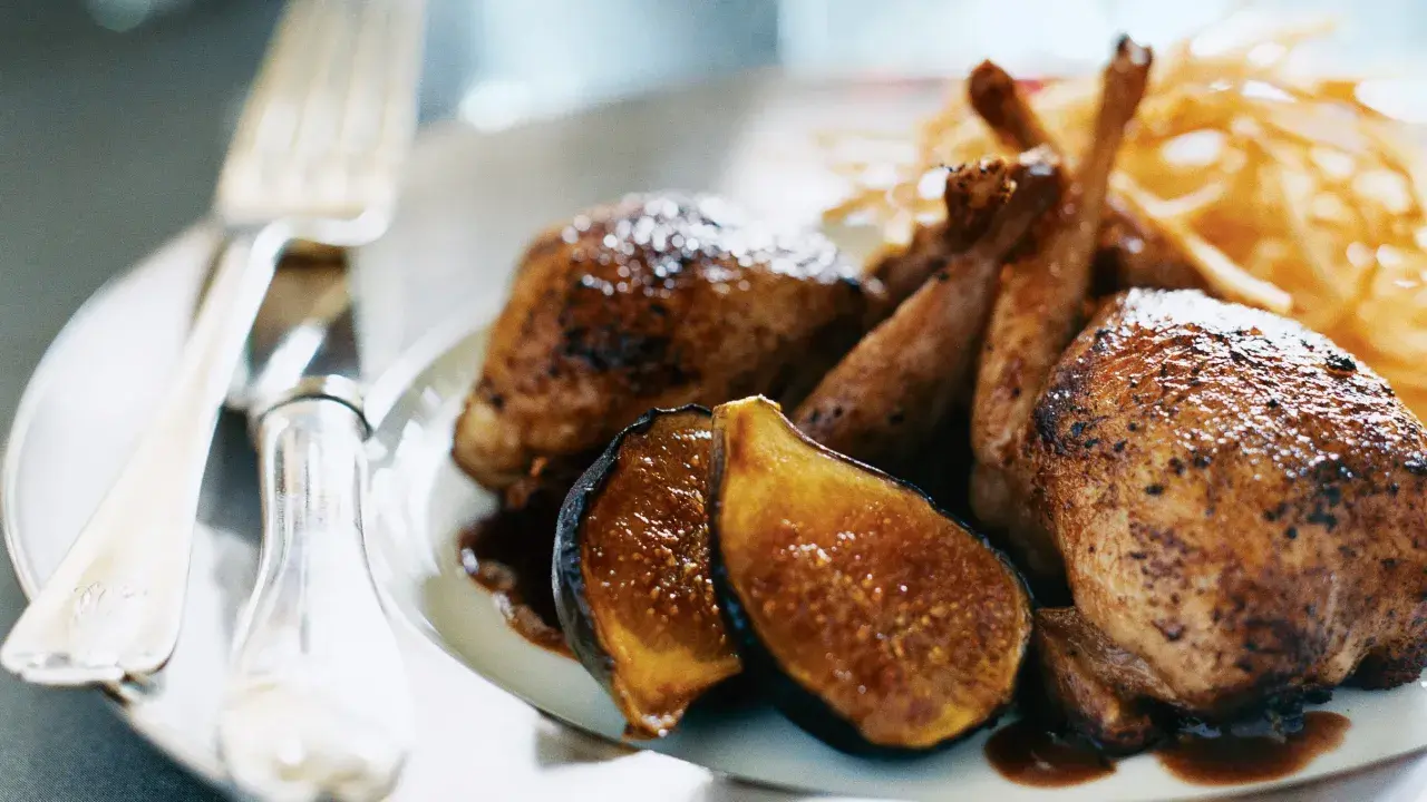 Délicieuse caille au four, servie avec des figues caramélisées et des frites croustillantes. Un plat savoureux prêt à être dégusté.