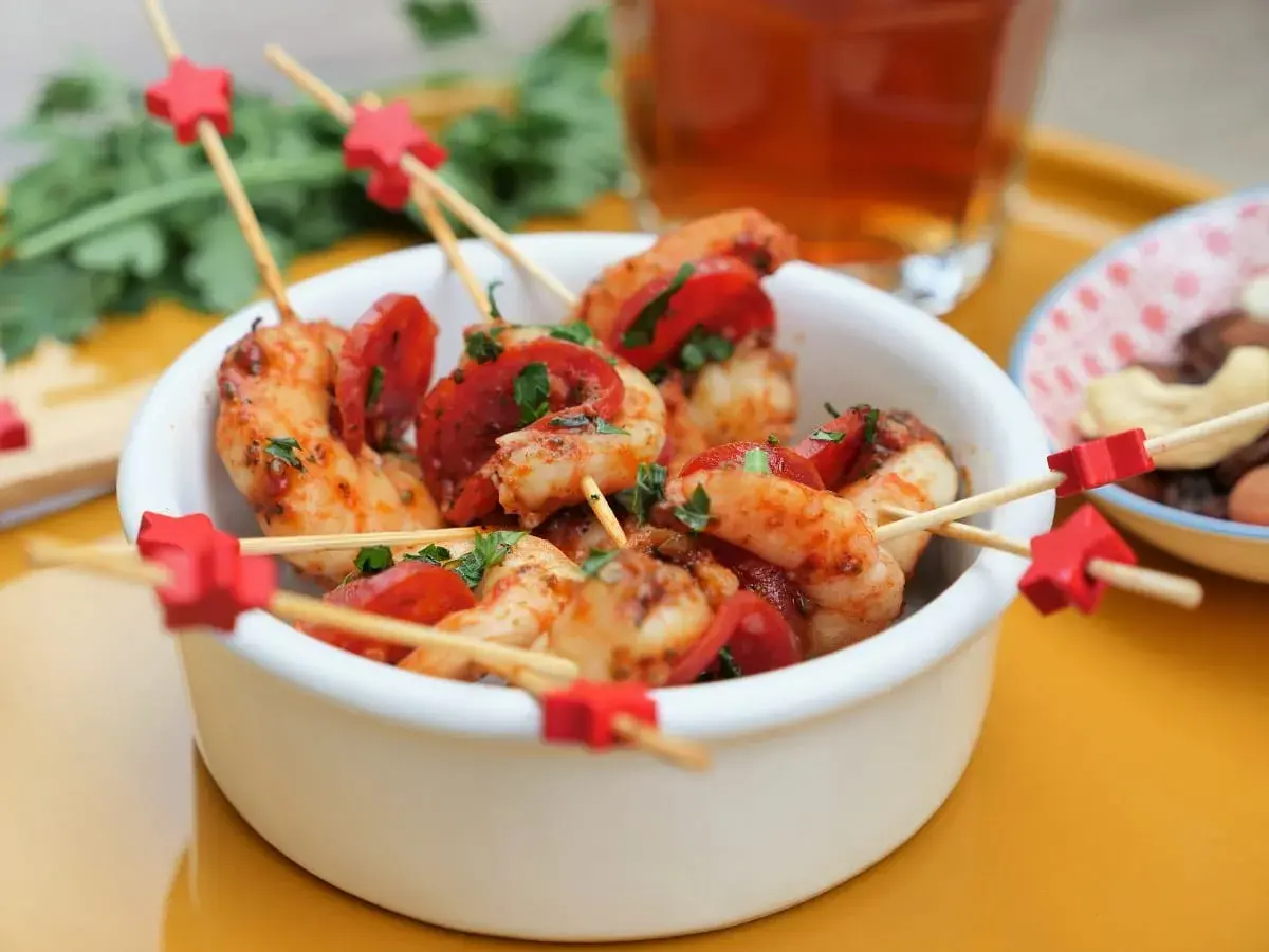 Brochettes crevette chorizo, garniture de persil frais, sur des bâtonnets décorés d'étoiles rouges. Un délice pour l'apéritif !