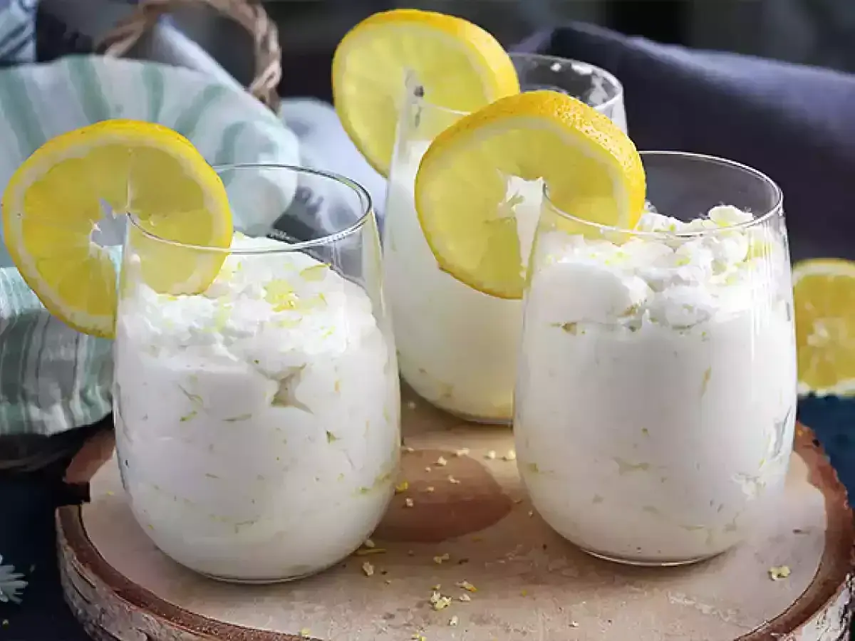 Trois verres de mousse au citron sans cuisson, décorés de rondelles de citron et de zeste. Un dessert frais et léger.