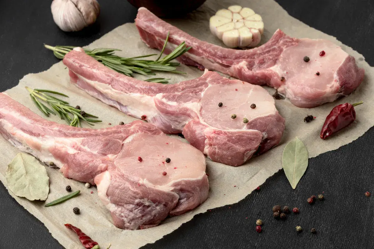 Belle découpe de cochon crue, assaisonnée de poivre et d'herbes, prête pour un festin.