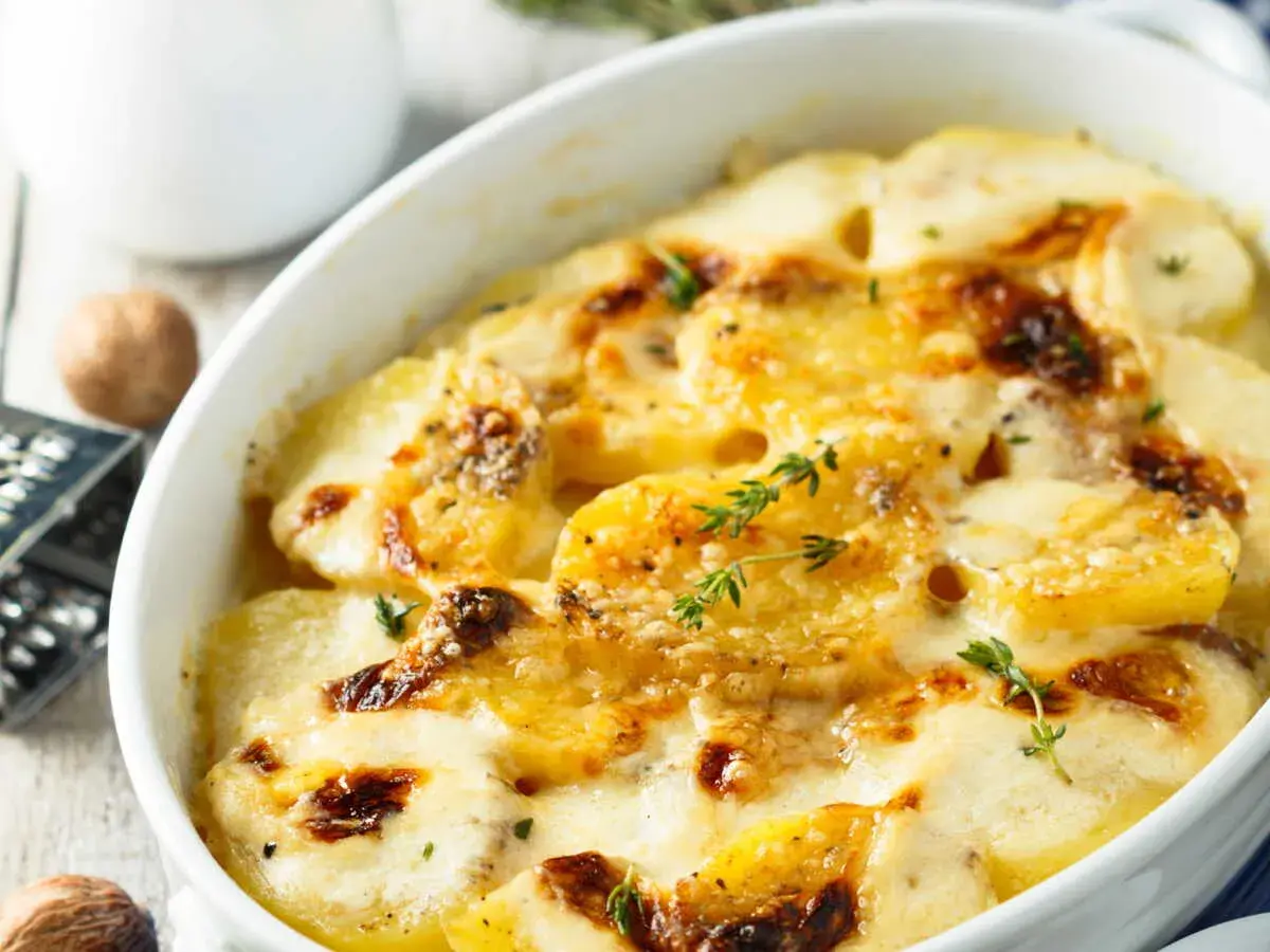 Gratin dauphinois tout juste sorti du four, le temps de cuisson idéal pour un plat crémeux et doré. Chaleur tournante pour une cuisson parfaite.