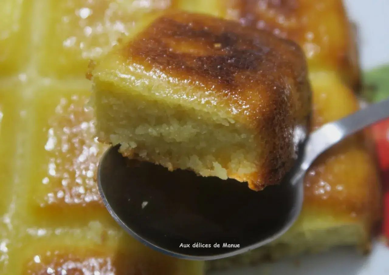 Une cuillère soulève un morceau d'un délicieux gâteau aux amandes sans beurre, doré et moelleux.