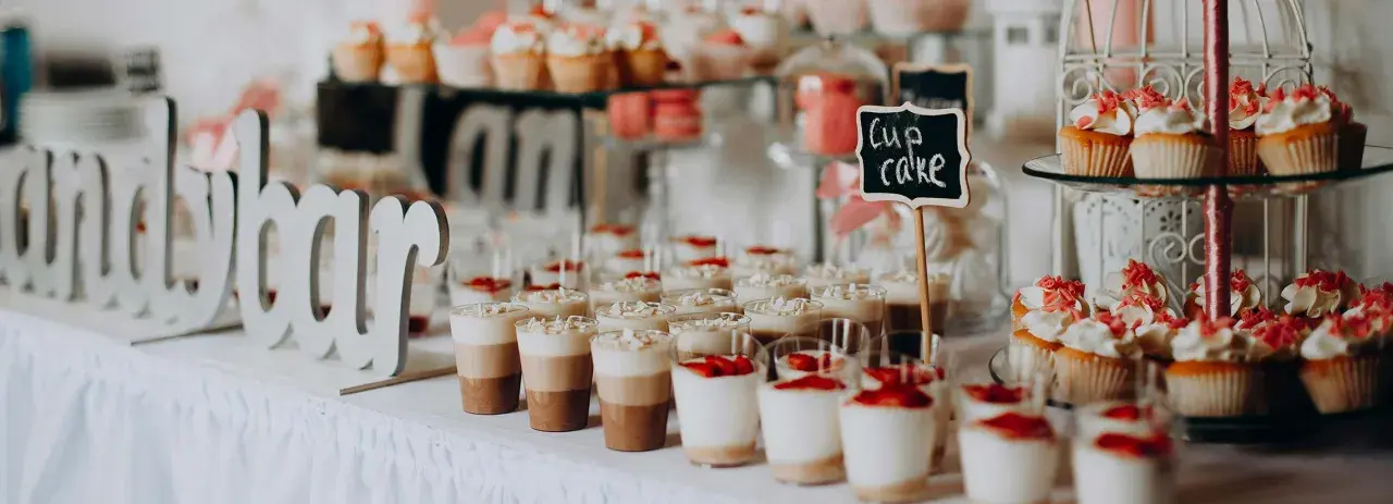 Un buffet de desserts festif, parfait pour une idée repas mariage été, avec des cupcakes, verrines et macarons.