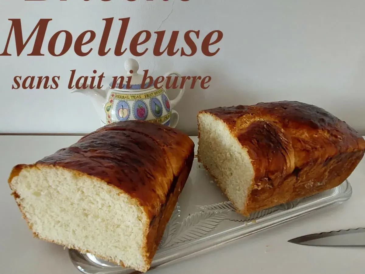 Deux belles brioches moelleuses sans lait ni beurre, dorées et appétissantes, prêtes à être dégustées.