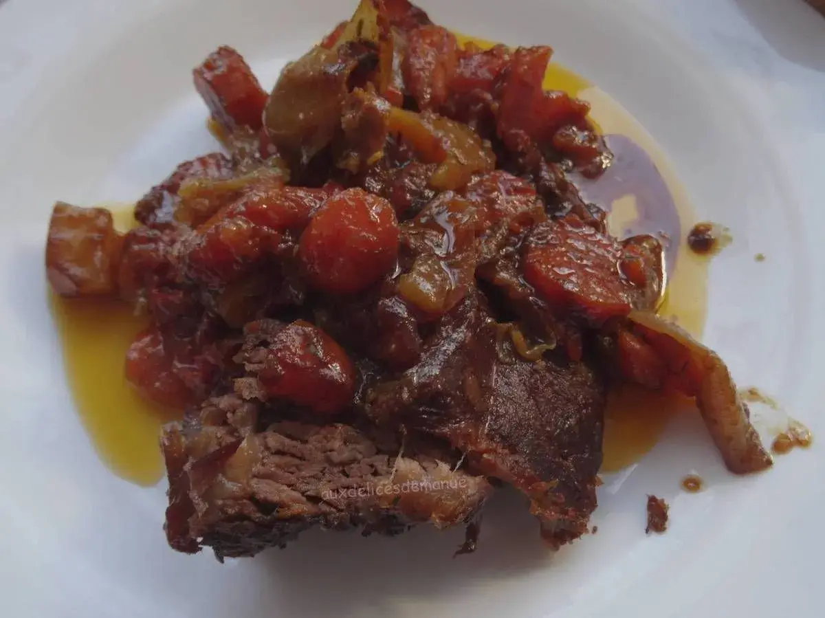 Un morceau de côte de bœuf mijoté, nappé d'une sauce aux tomates et oignons caramélisés. Parfait pour une marinade pour côte de bœuf maison.