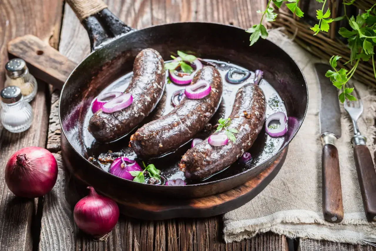 Boudin noir poêlé avec oignons rouges. Astuce pour comment cuire le boudin noir sans qu'il éclate : le piquer légèrement avant cuisson.