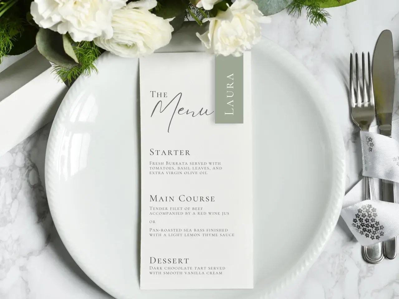 Le menu de mariage de Laura, avec des fleurs blanches et une présentation élégante.
