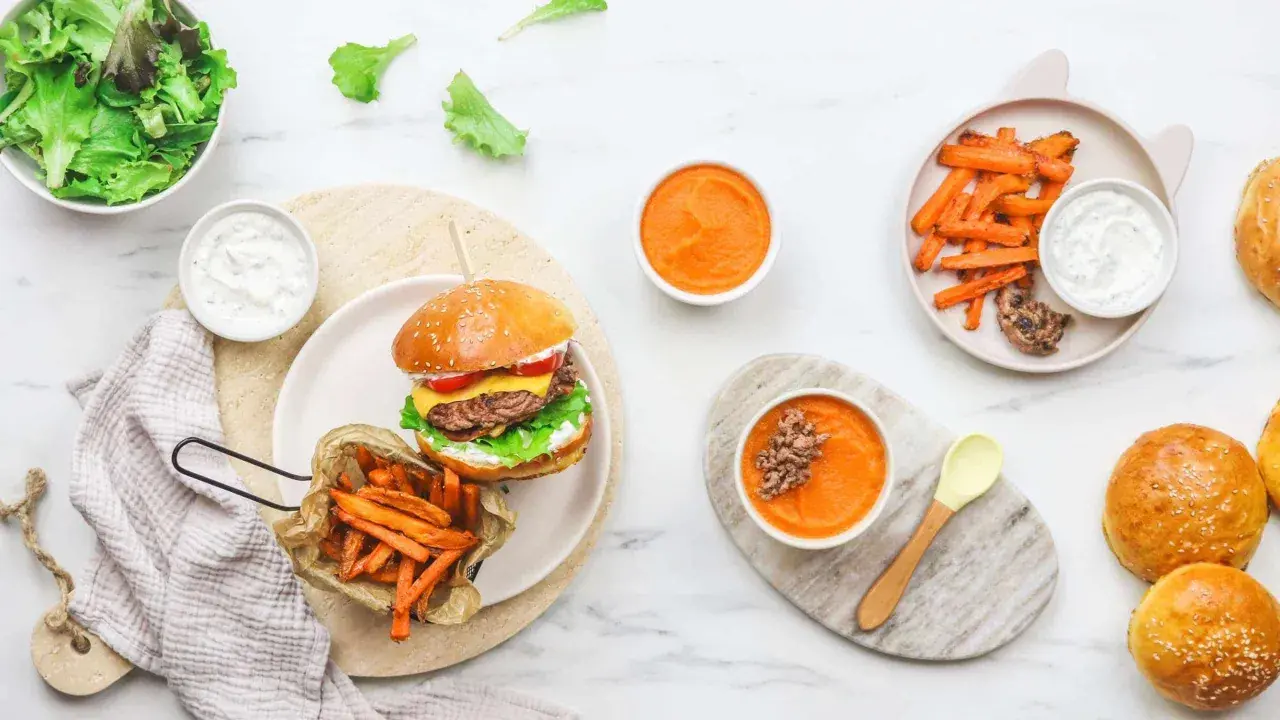 Un délicieux burger enfant avec frites de patate douce, purée de carottes et salade verte. Un repas complet et appétissant pour les petits gourmands.