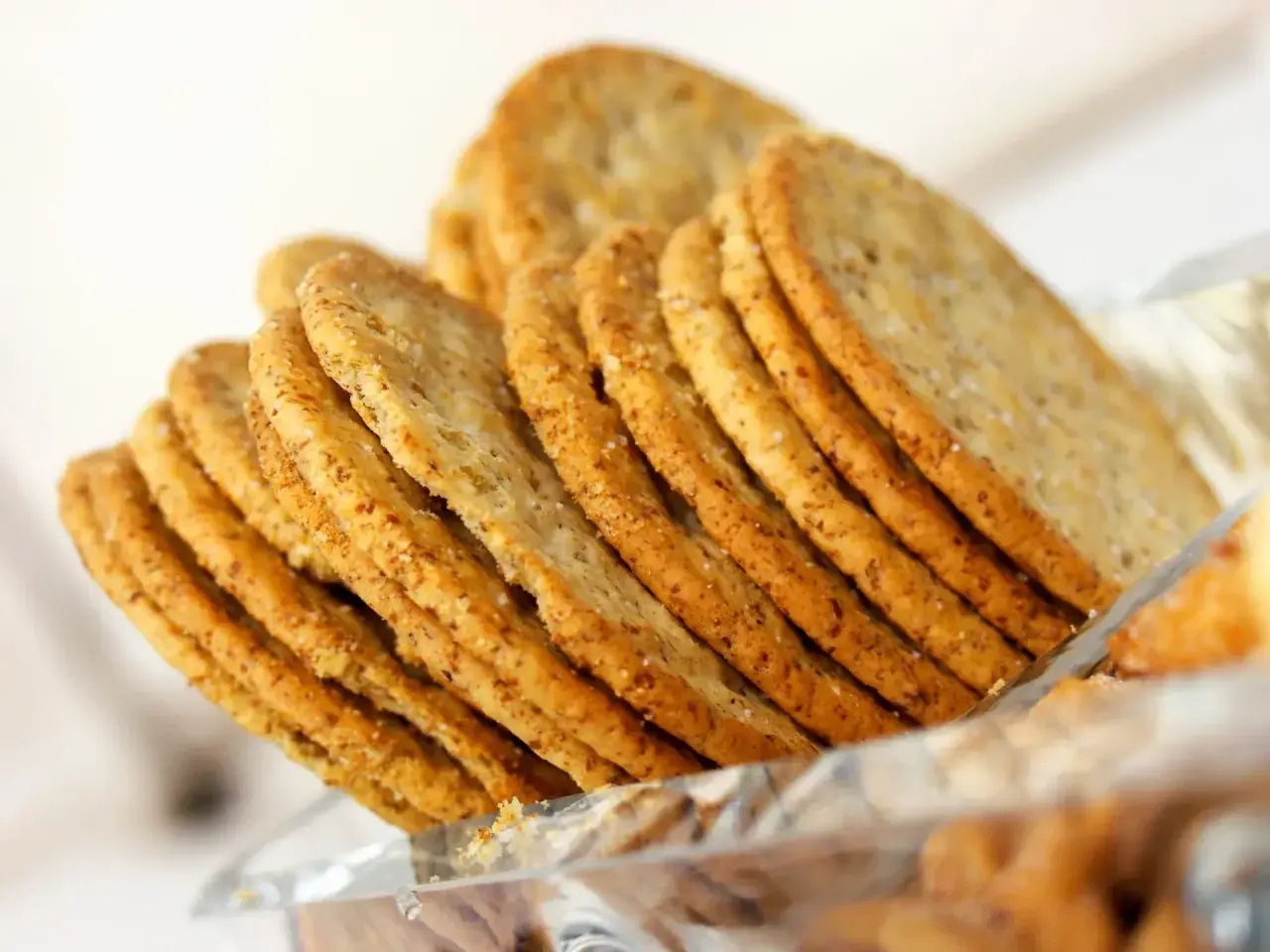 Une pile de crackers croustillants, parfaits pour une recette de crackers fromage. Ils sont dorés et parsemés de sel.