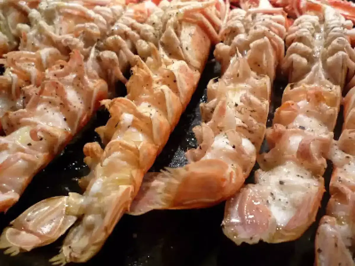 Langoustines grillées, assaisonnées de poivre, prêtes pour un barbecue savoureux.