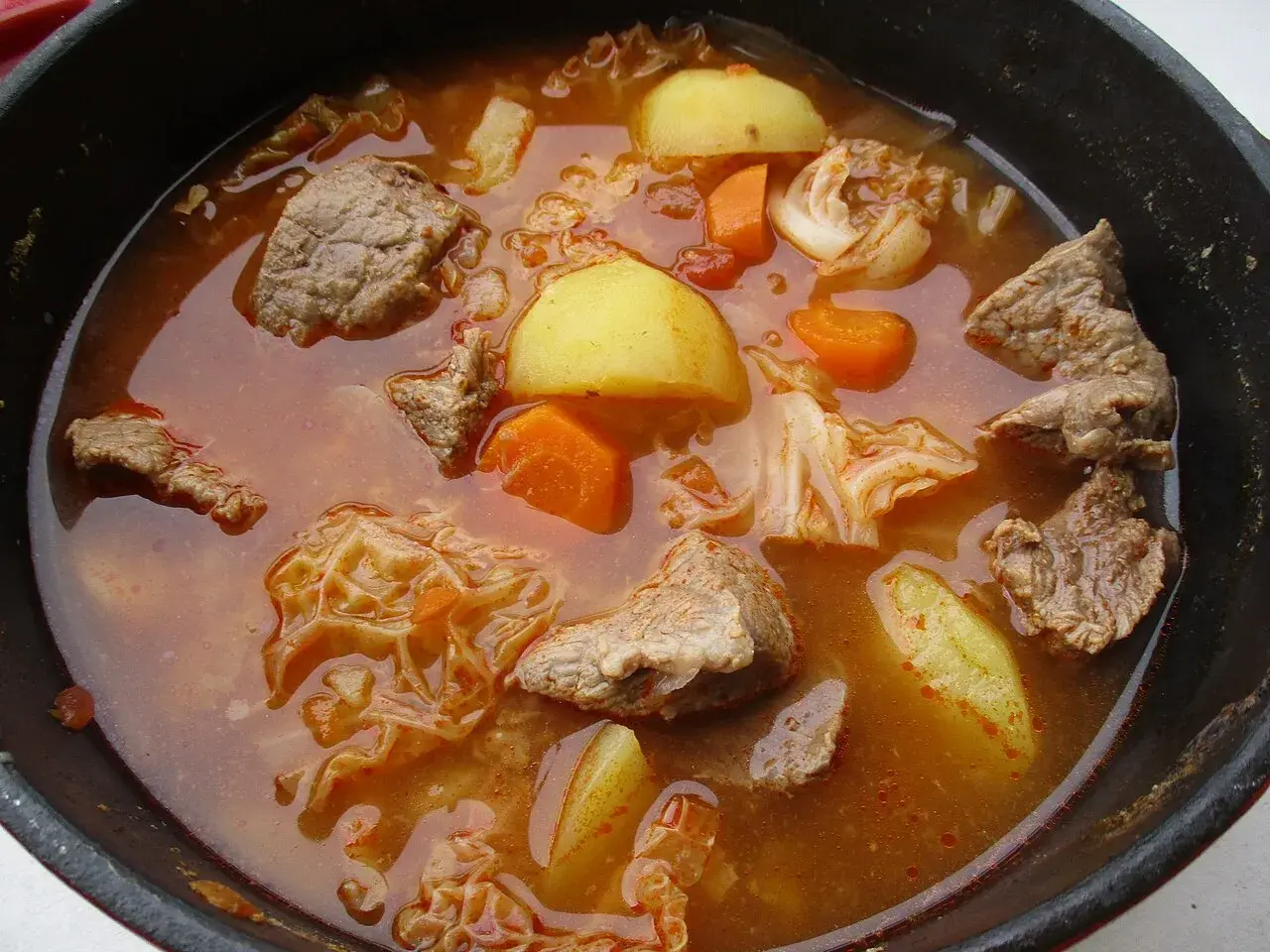 Un plat mijoté réconfortant, digne d'une recette viking viande : morceaux de bœuf, pommes de terre, carottes et chou dans un bouillon savoureux.