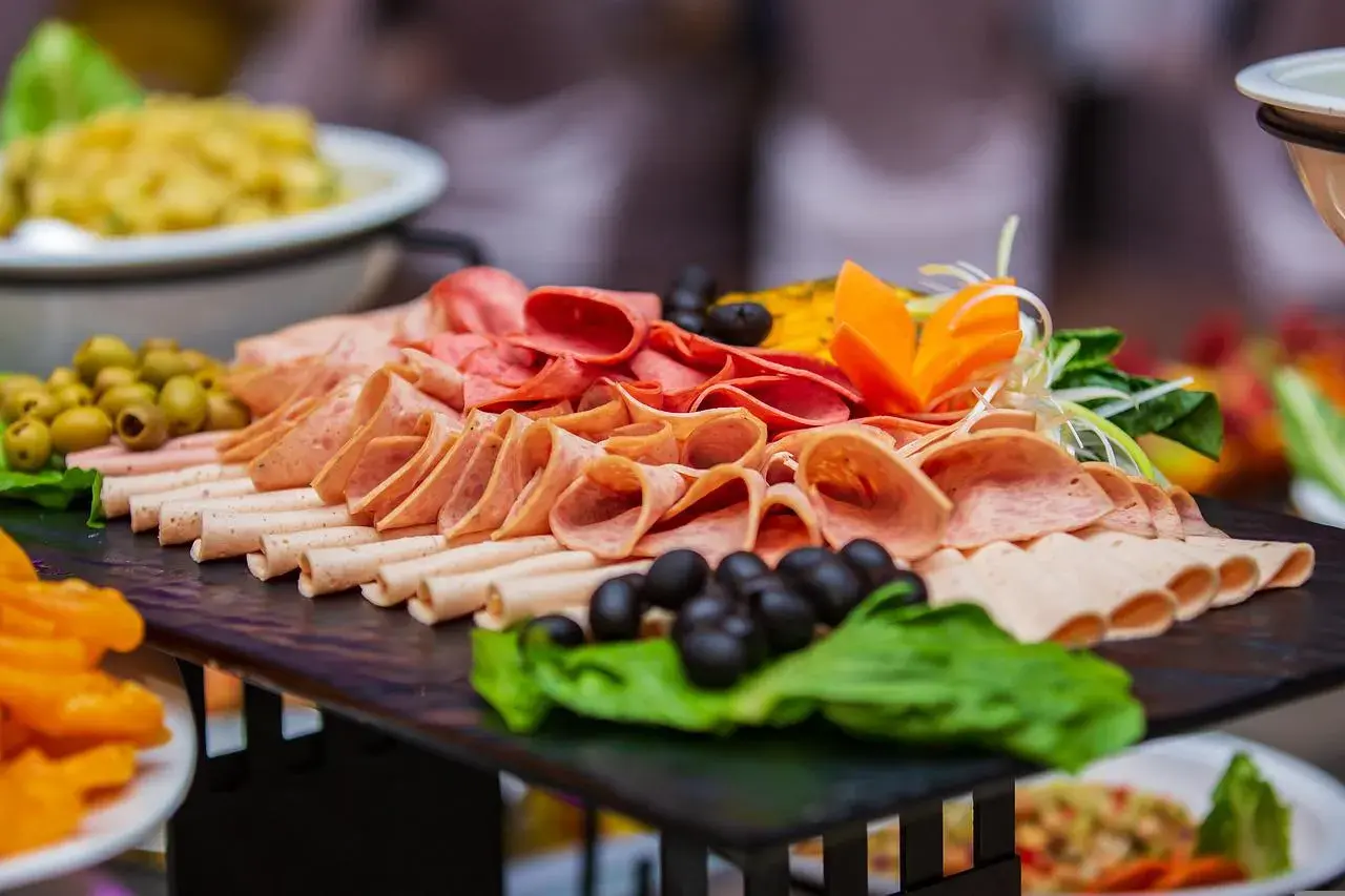 Plateau de charcuterie variée, olives et garnitures, parfait pour un repas champêtre pour 50 personnes.