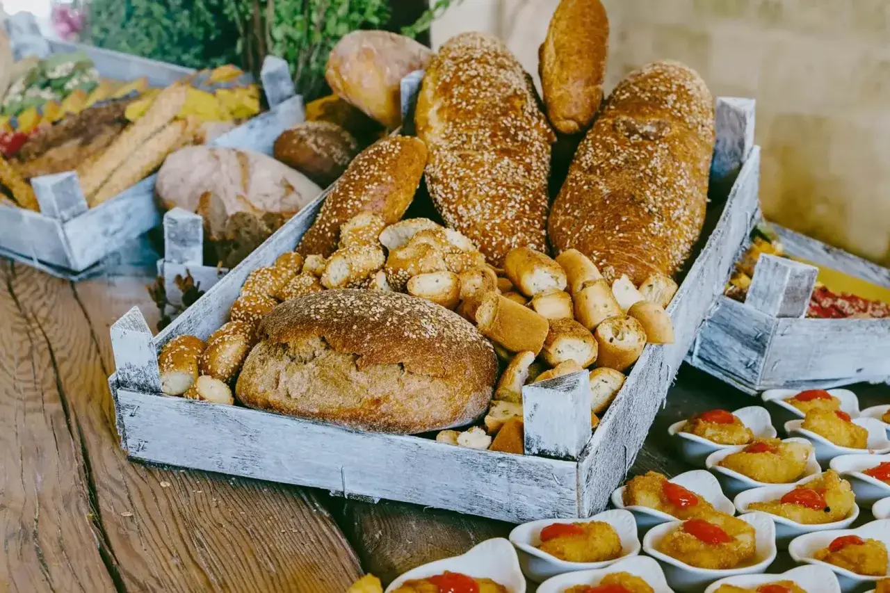 Plateau de pains variés, idéal pour un traiteur prix moyen par personne. Des pains ronds, des baguettes et des petits pains croustillants.