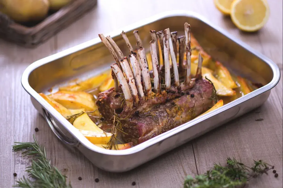 Un délicieux côte d'agneau rôti au four, accompagné de pommes de terre dorées et de romarin frais. Un plat savoureux prêt à être dégusté.