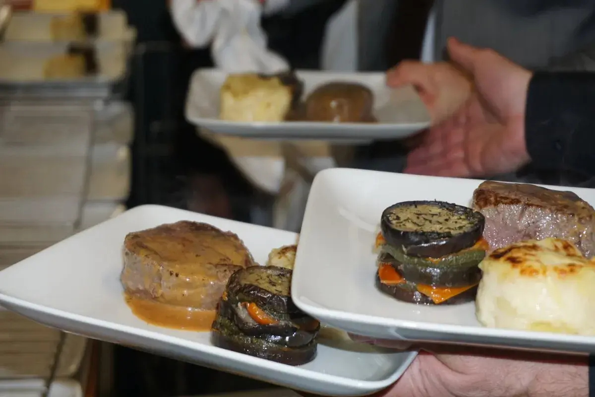 Un délicieux repas chaud de mariage avec des médaillons de bœuf, des légumes grillés et une purée gratinée.
