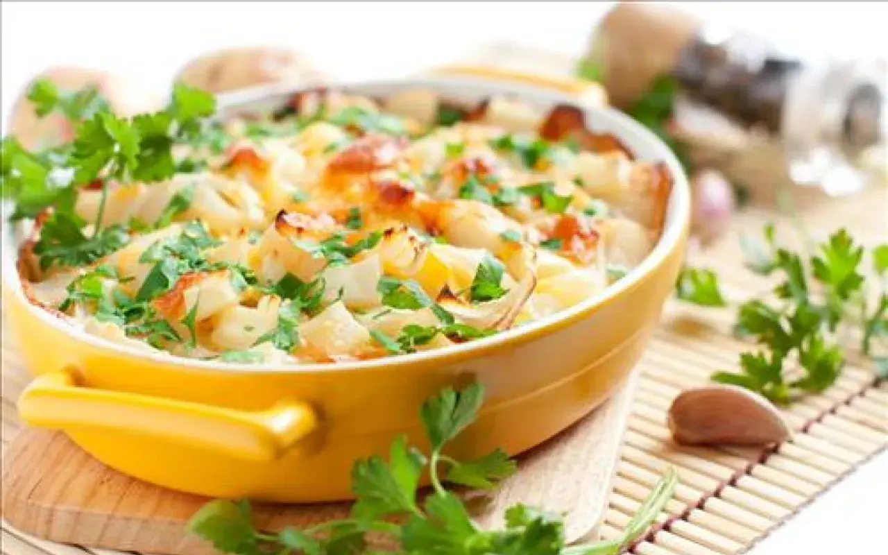 Gratin de chou-fleur et pommes de terre, une des meilleures recettes pour ceux qui n'aiment pas les légumes. Garniture de persil frais.