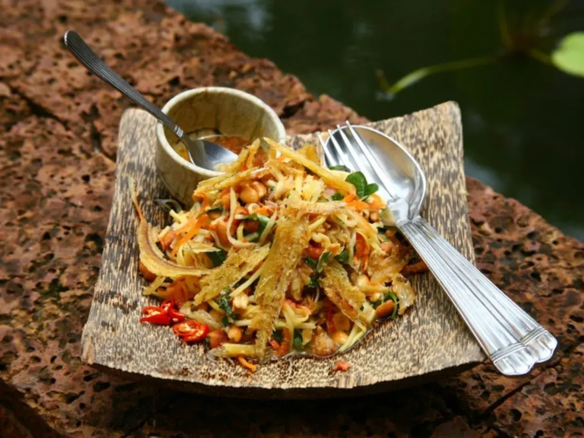 Salade croquante de poisson séché, un plat cambodgien savoureux avec des carottes râpées, des cacahuètes et des piments.