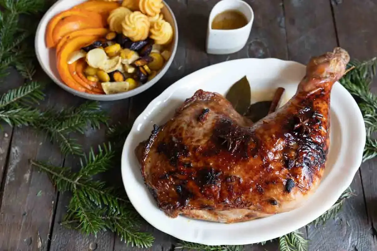 Une cuisse de dinde rôtie, brillante et savoureuse, parfaite pour une recette cuisse de dinde originale. Accompagnée de légumes et de petites bouchées.