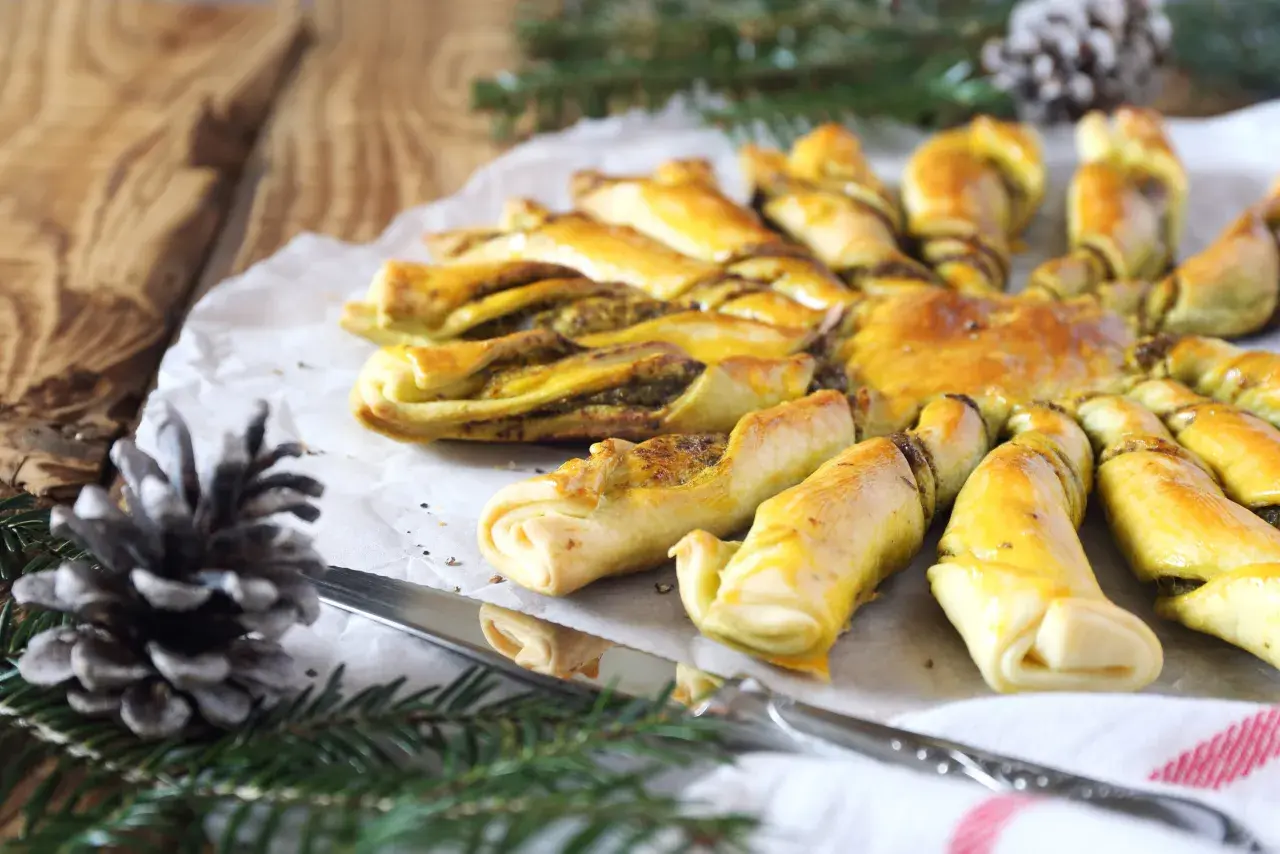 Tarte soleil au pesto, dorée et appétissante, prête à être partagée. Un délice pour les fêtes.