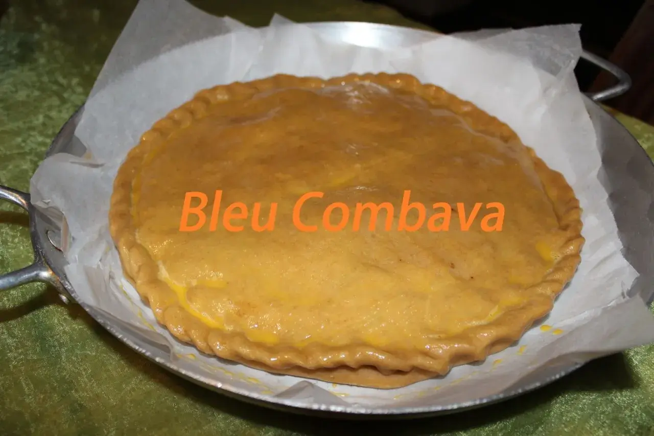 Une empanada gallega dorée, prête à être dégustée. Le texte "Bleu Combava" est superposé.