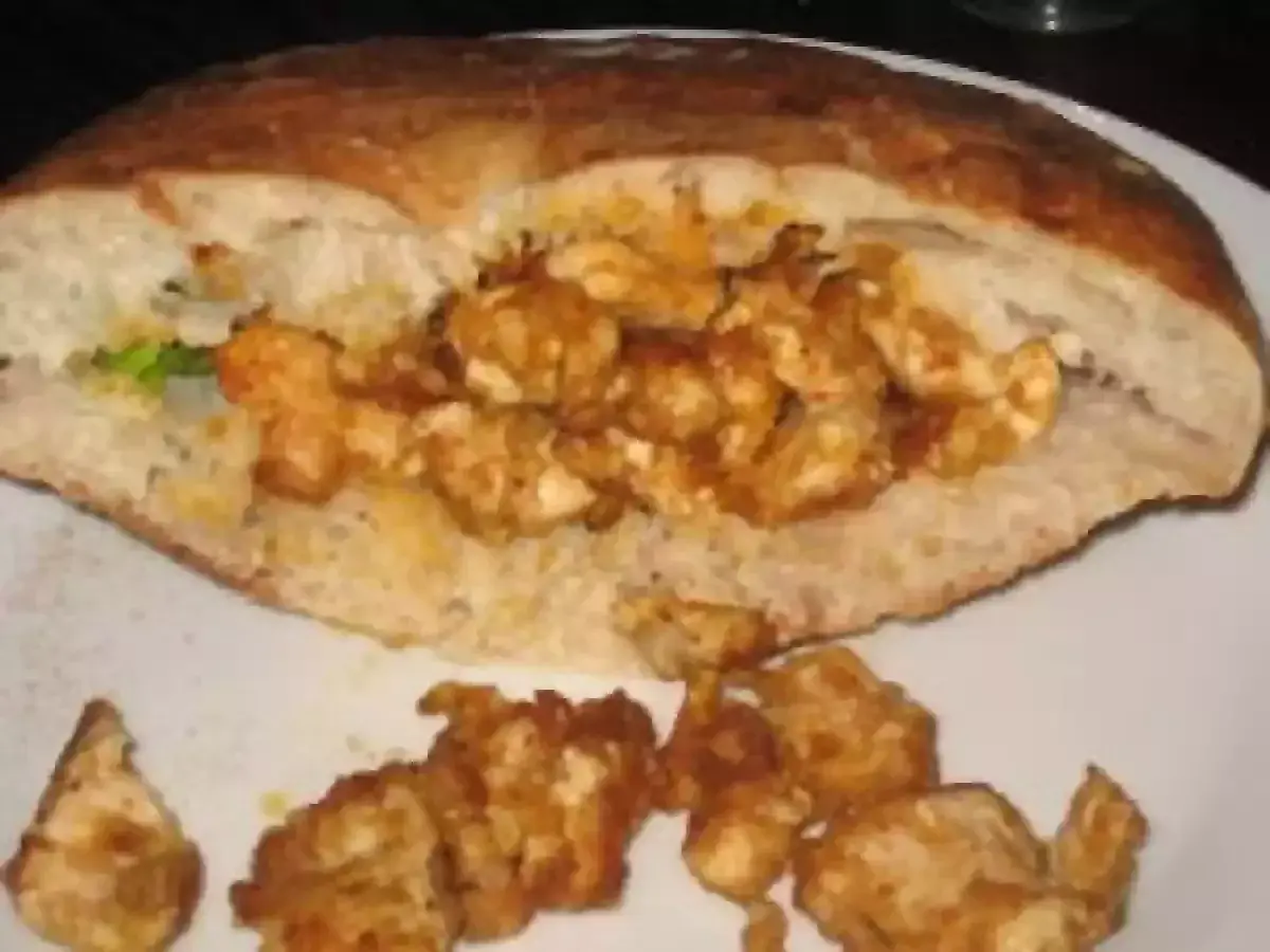 Un pain garni de morceaux de poulet épicés, prêt à déguster. Une recette kebab maison facile pour un repas savoureux.