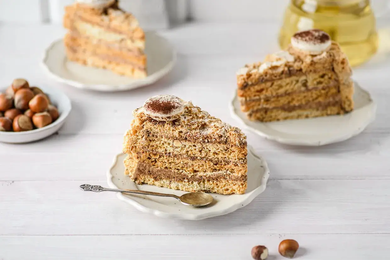 Tranches de gâteau moelleux aux noisettes de ma mamie, garnies de crème au chocolat et saupoudrées de cacao. Un délice !