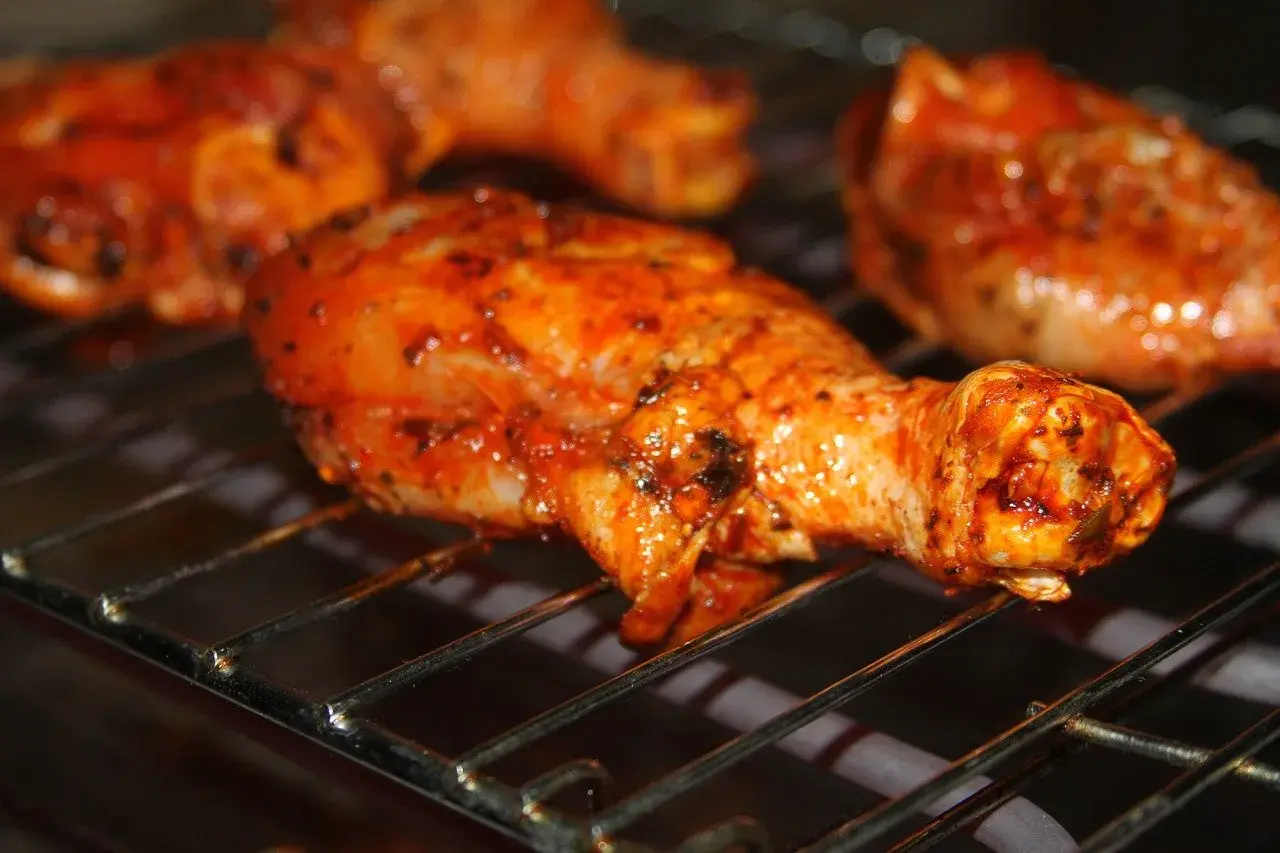 Cuisses de poulet marinées, grillées au barbecue charbon, dégoulinant de sauce savoureuse.