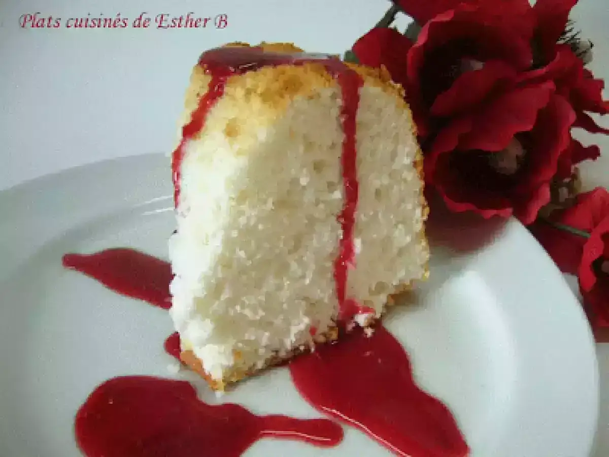 Tranche de g&acirc;teau des anges a&eacute;rien, napp&eacute;e de coulis rouge, inspir&eacute;e d'une recette Marmiton. D&eacute;cor&eacute;e de fleurs rouges.