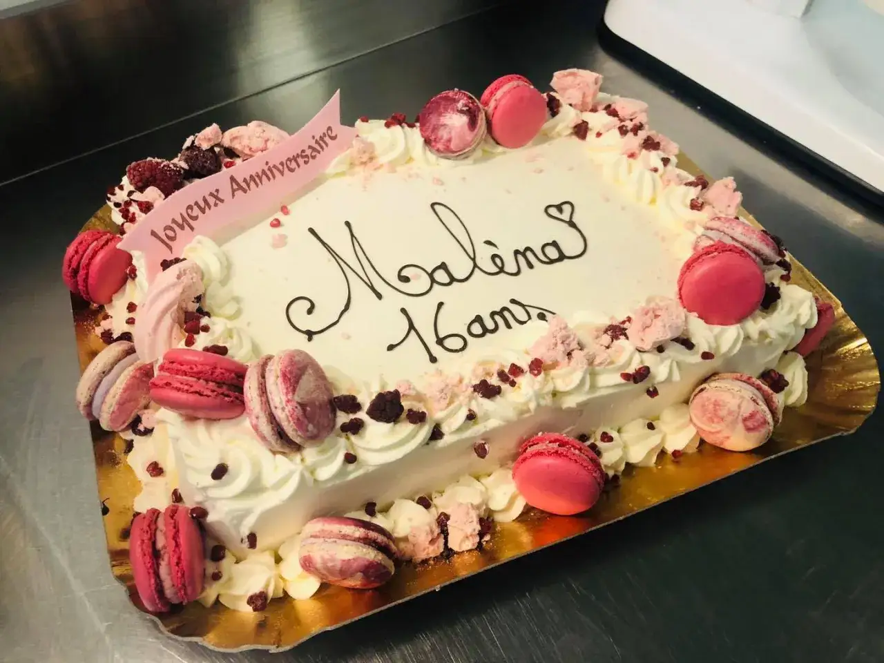 Gâteau rectangulaire décoré de macarons roses et de fruits rouges, idéal pour une recette de gâteau d'anniversaire pour 20 personnes.