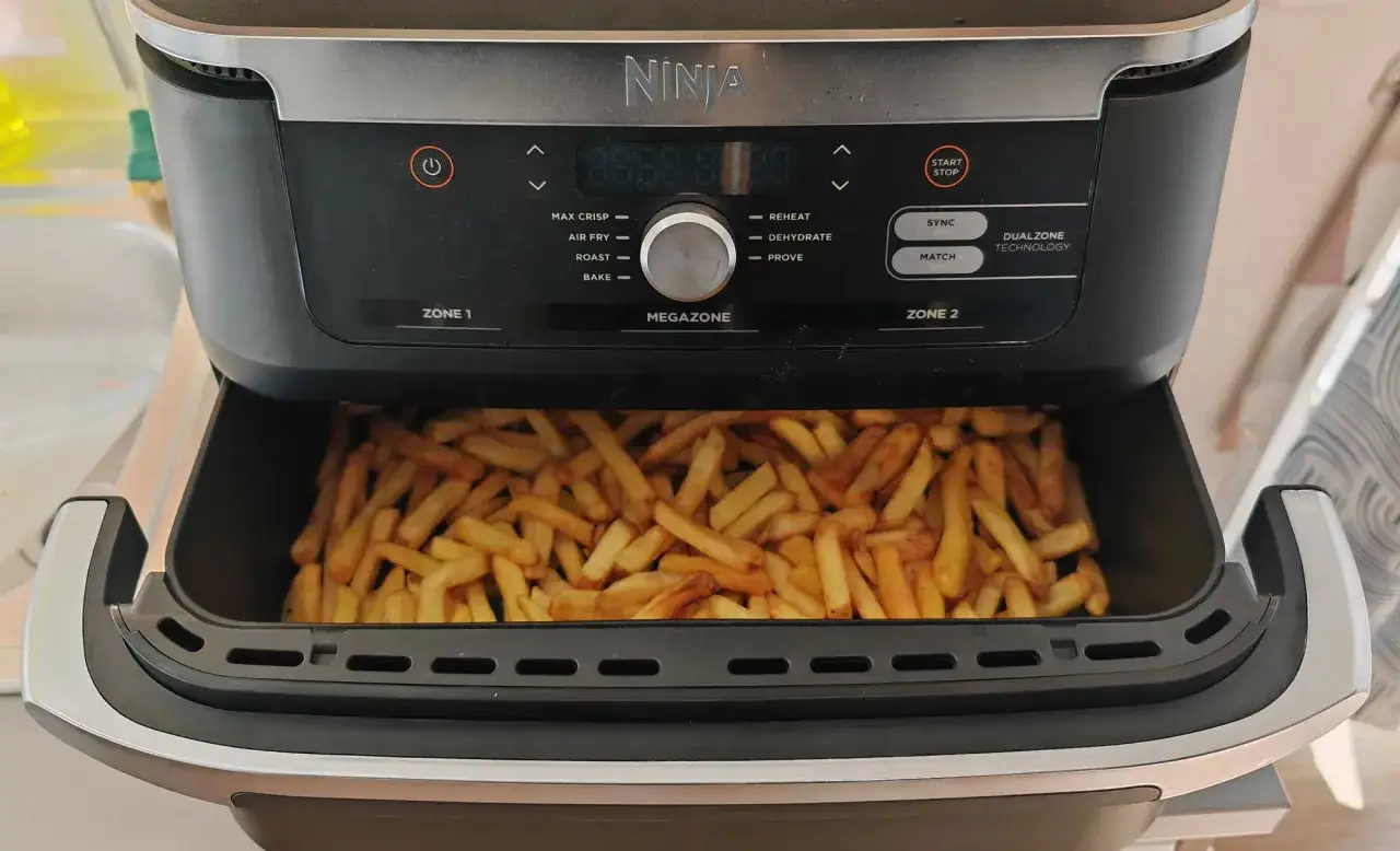 Frites maison dorées et croustillantes dans un airfryer Ninja, prêtes à être dégustées.