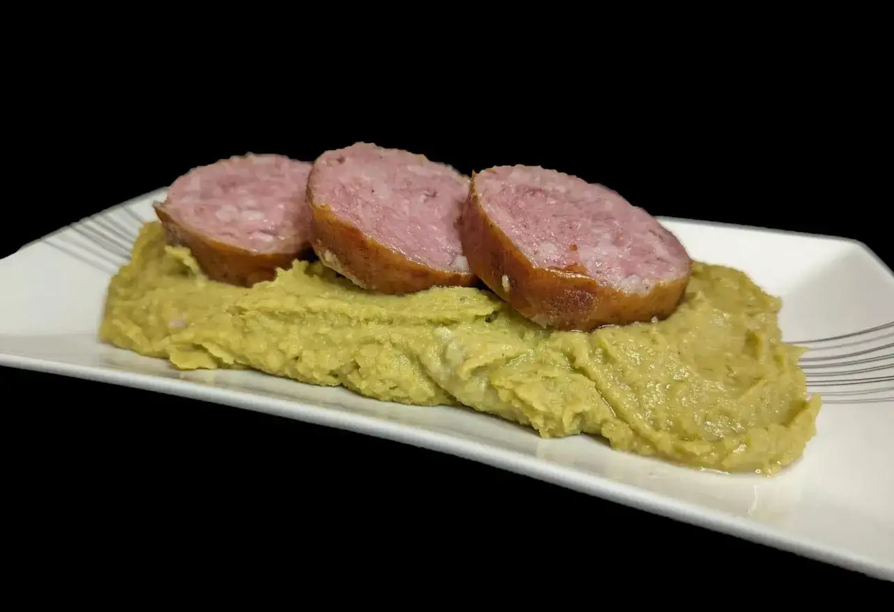 Trois tranches de saucisse sur une purée de pois cassés, un plat réconfortant.